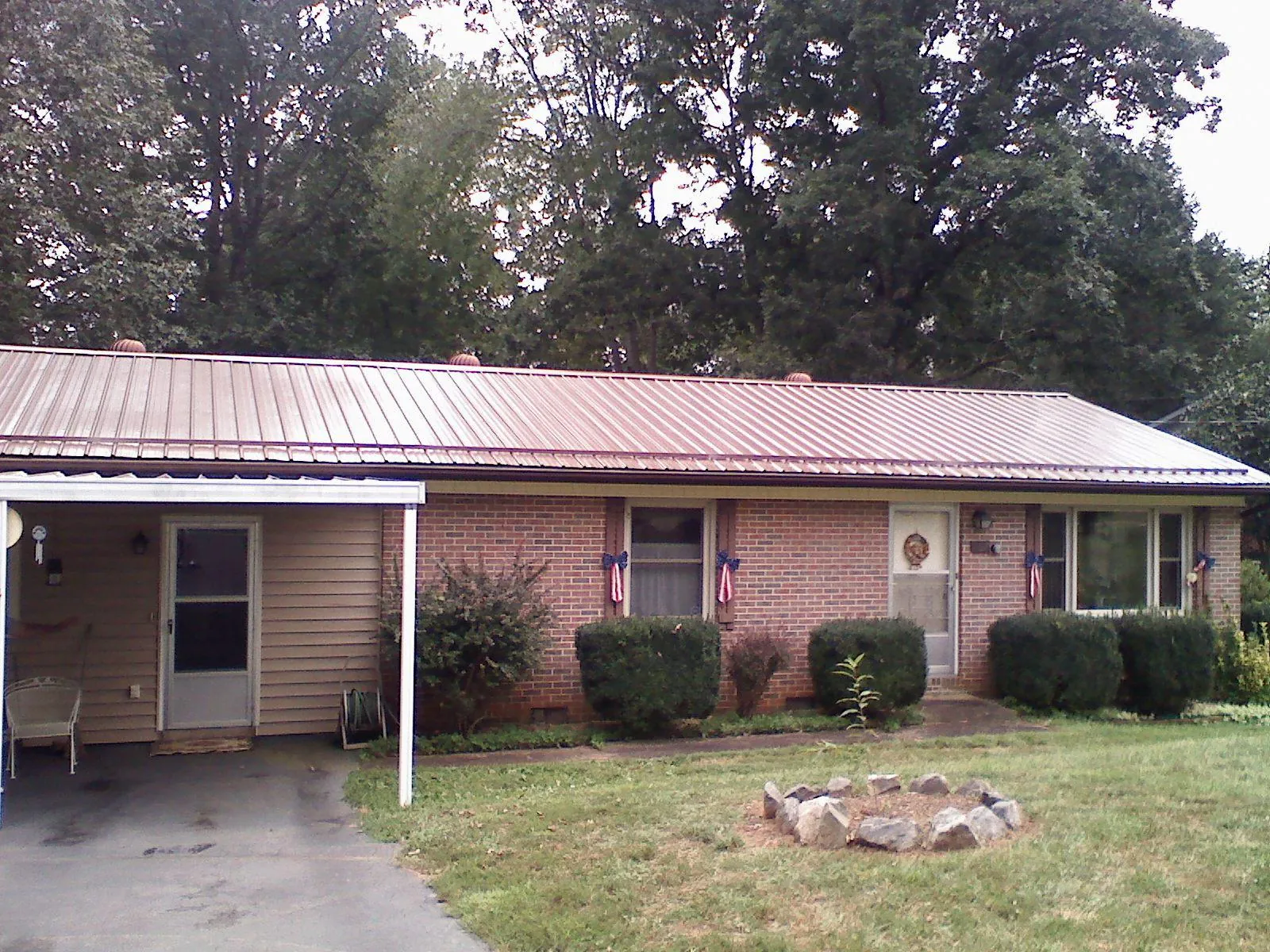Bronze metal roof and carport on a brick ranch home — Roof Repair work by our crew in Morrisville